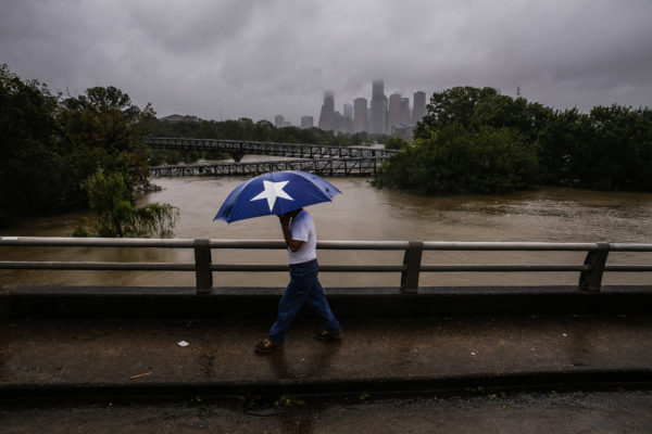 Armando Bustamante walks along Studemont Street over Buffalo Bayou as flood waters from Hurricane Harvey flow toward downtown Houston on Tuesday, Aug. 29, 2017. Michael Ciago/Houston Chronicle