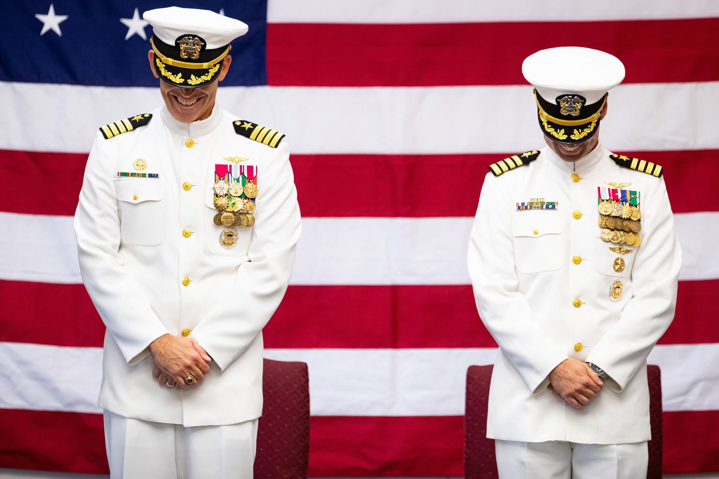  Out going Captain Philip Brock, left and incoming Captain Christopher Janson smile during the invocation of the Naval Air Station Corpus Christi change of command and retirement ceremony on Wednesday, July 31, 2019. 