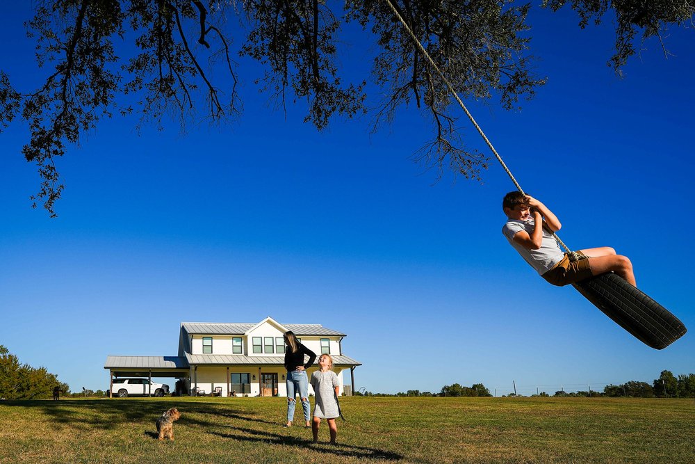  Reid Rolen, 9, plays on a tire swing as his sister Lyla, 5, and his mother Mandi Rolen look on Wednesday, Oct. 16, 2024, in Cuthand, Texas. Residents in the Sulphur River Basin will be impacted if the proposed Marvin Nichols Reservoir in northeast T