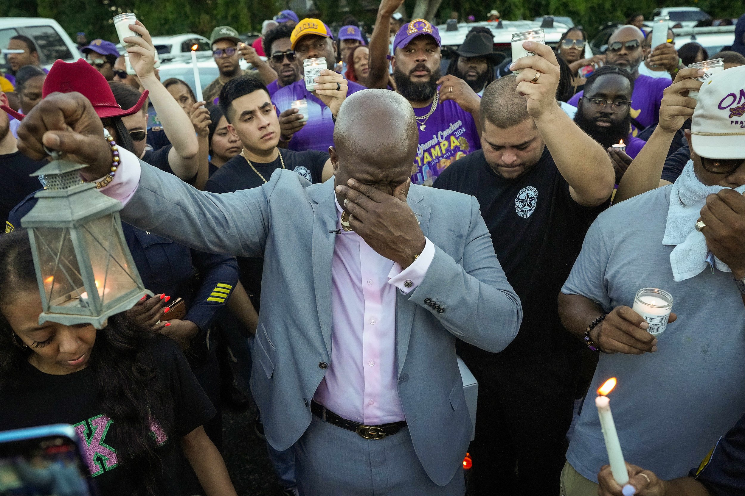 Keio Gamble wipes his eyes as he lifts a candle with fellow mourners during a vigil for Dallas police officer Darron Burks at For Oak Cliff on Friday, Aug. 30, 2024, in Dallas. Burks was killed and two other officers were wounded in a shooting Thurs