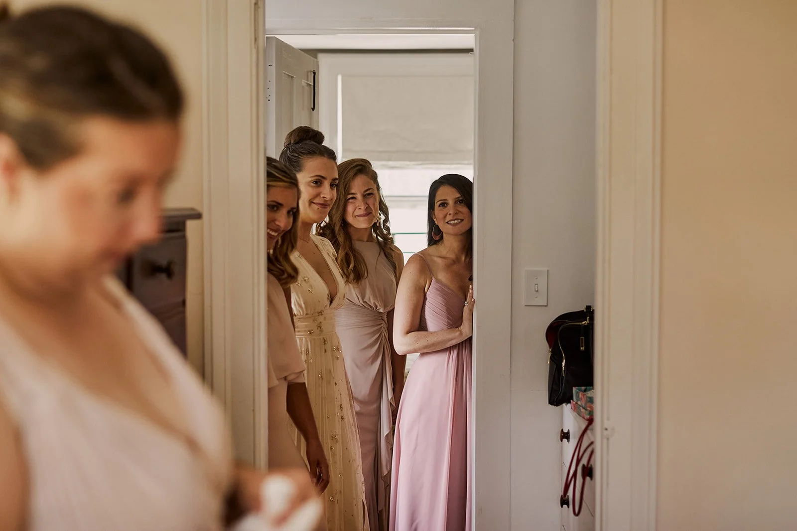 Bridesmaids look on from the other room