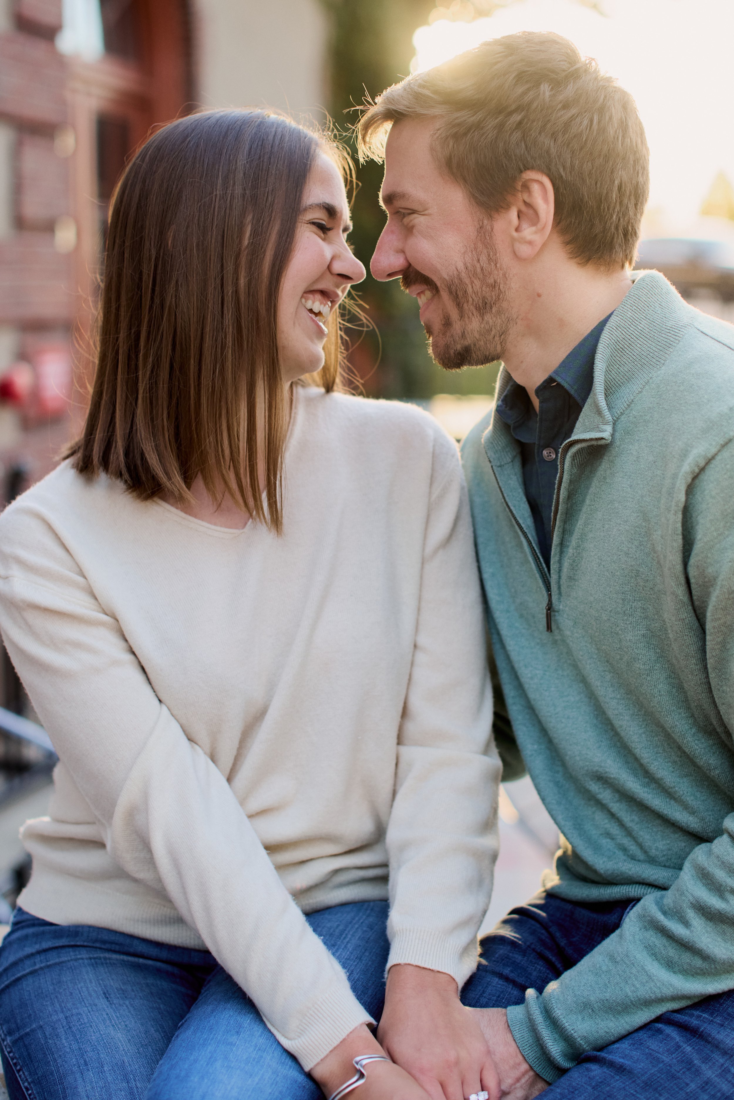 A couple leans their heads close together, smiling