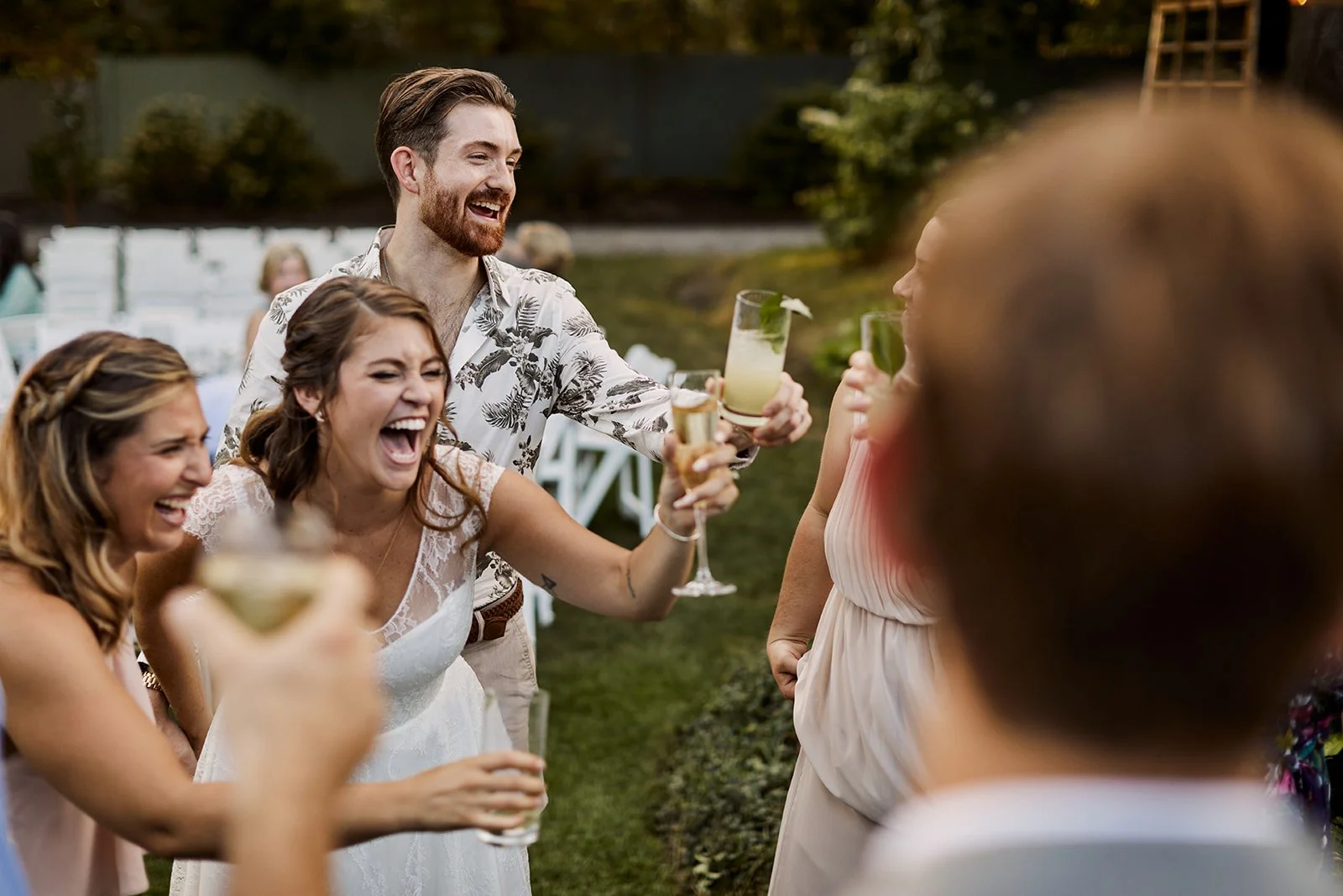 Guests and the bride clink glasses outside