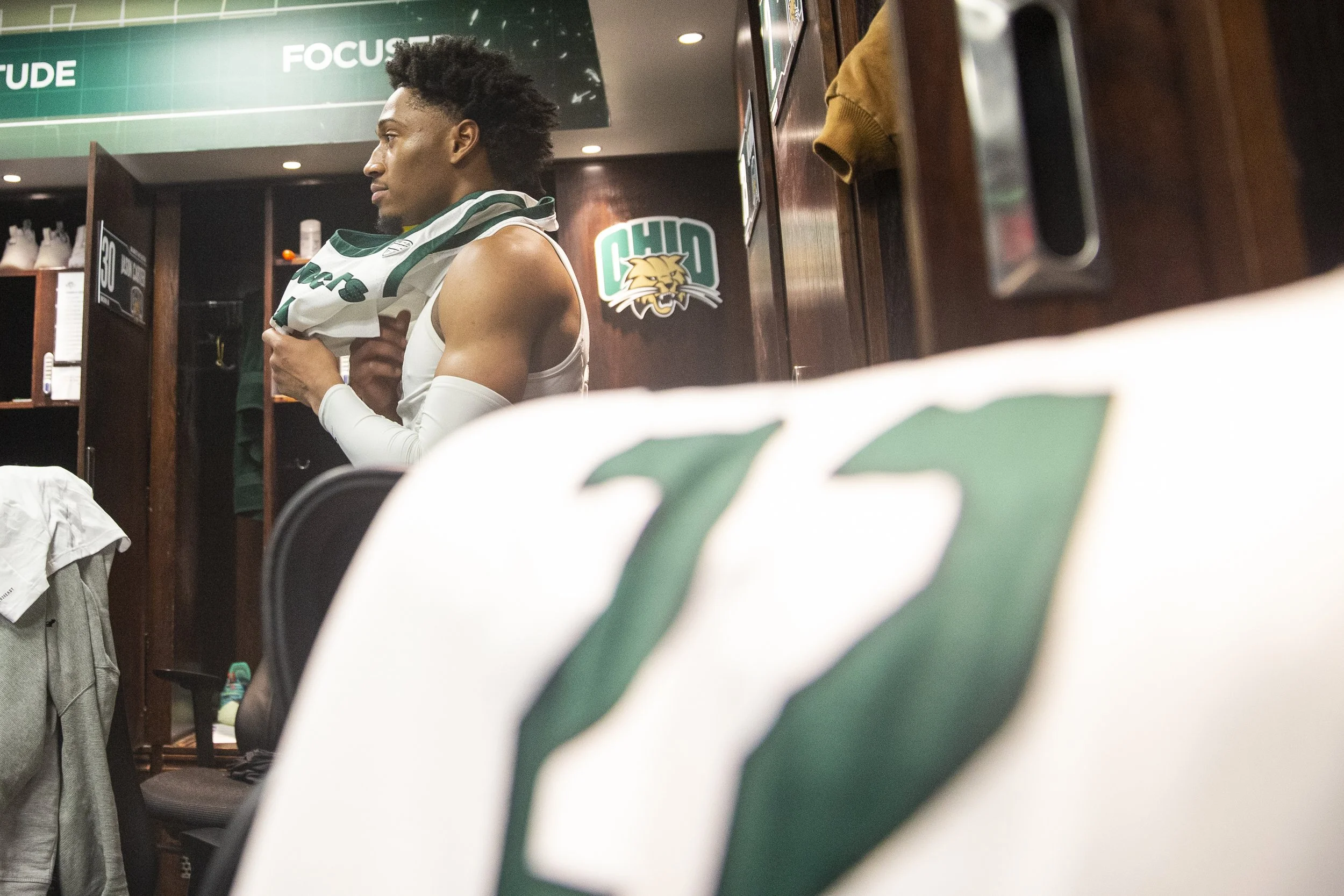  Miles Brown puts on his jersey prior to heading out onto the court for the game against Robert Morris.  