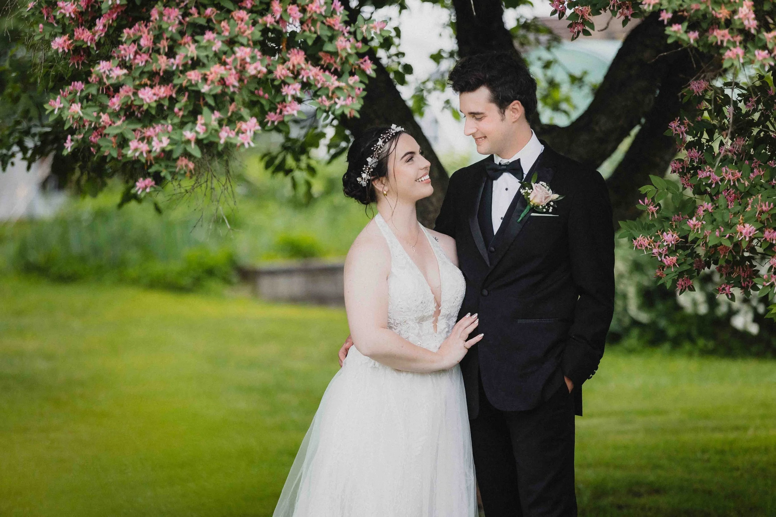 Rainy wedding day photo of newlyweds under a lilac tree, captured in Montreal.