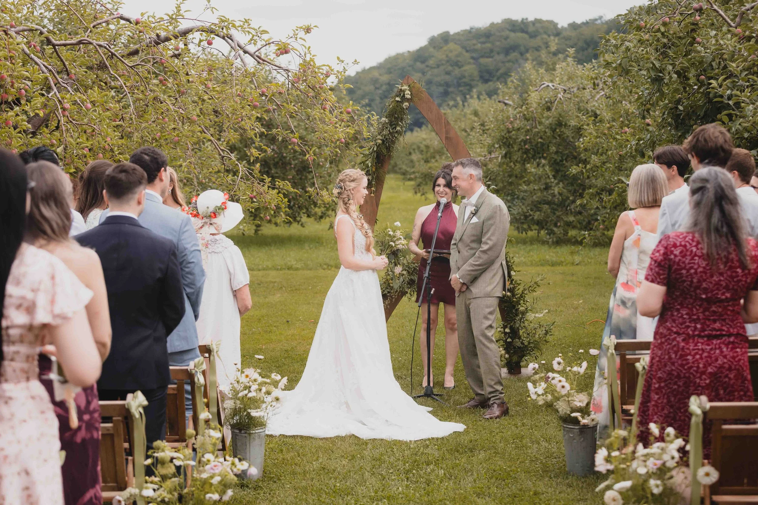 Bride and groom standing at the altar during their orchard wedding ceremony at Verger Jude-Pomme in Oka, Quebec.
