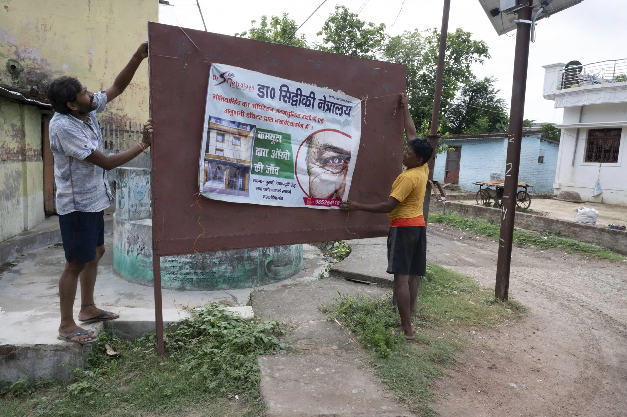 Shikarpur village - they find somewhere to hang their advertising banner