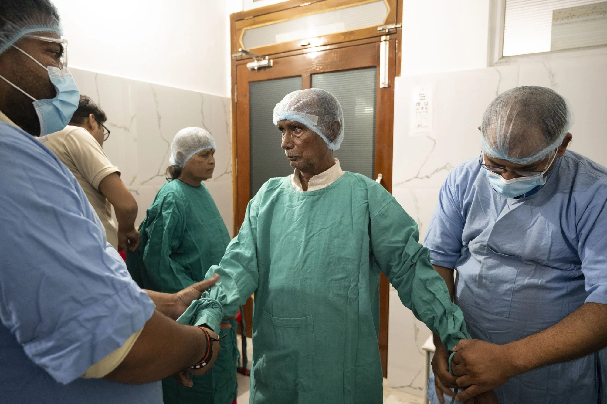 Other staff members ternderly dress the surgical patients in their theatre greens