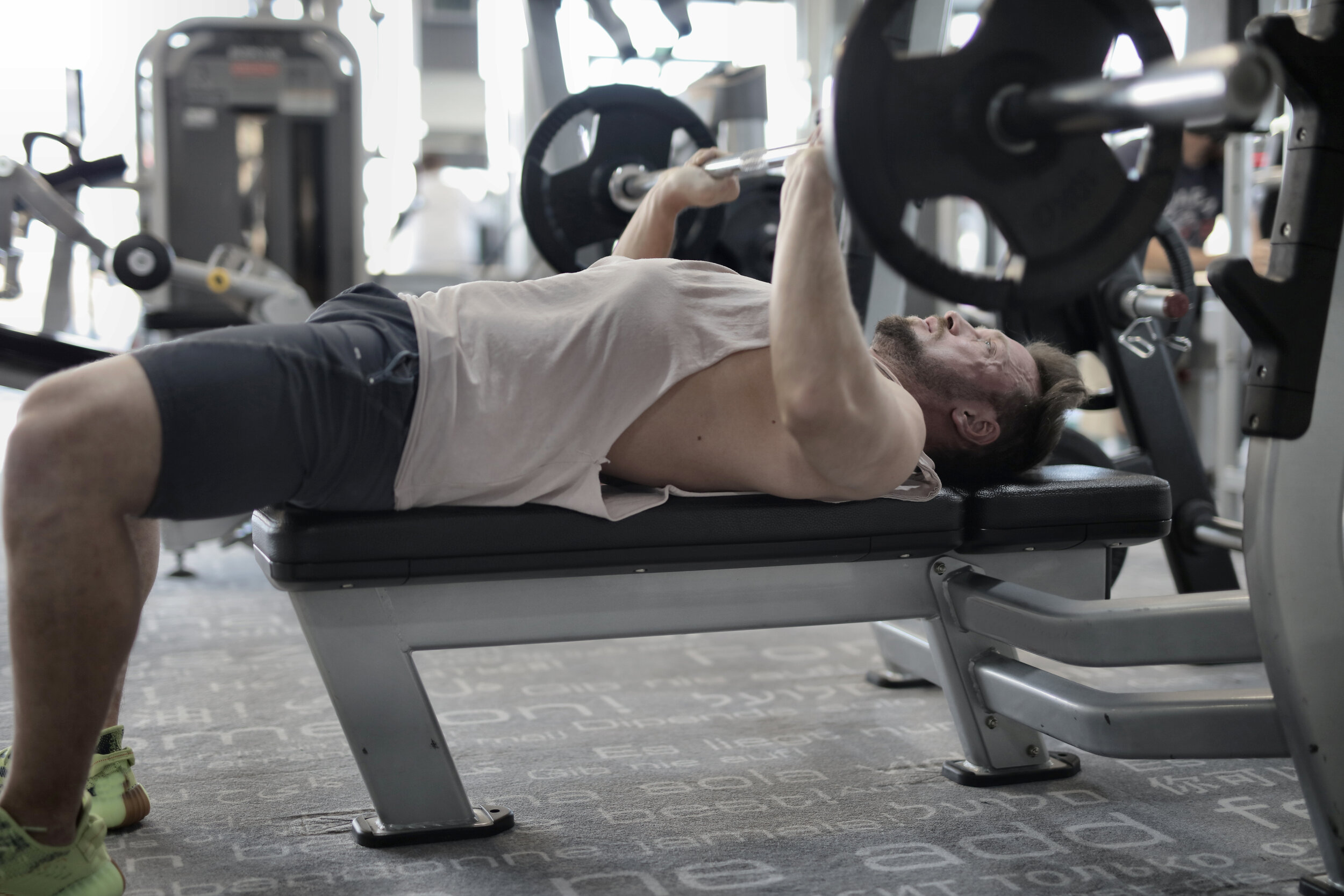 Canva - Strong sportsman working out on bench in modern gym.jpg