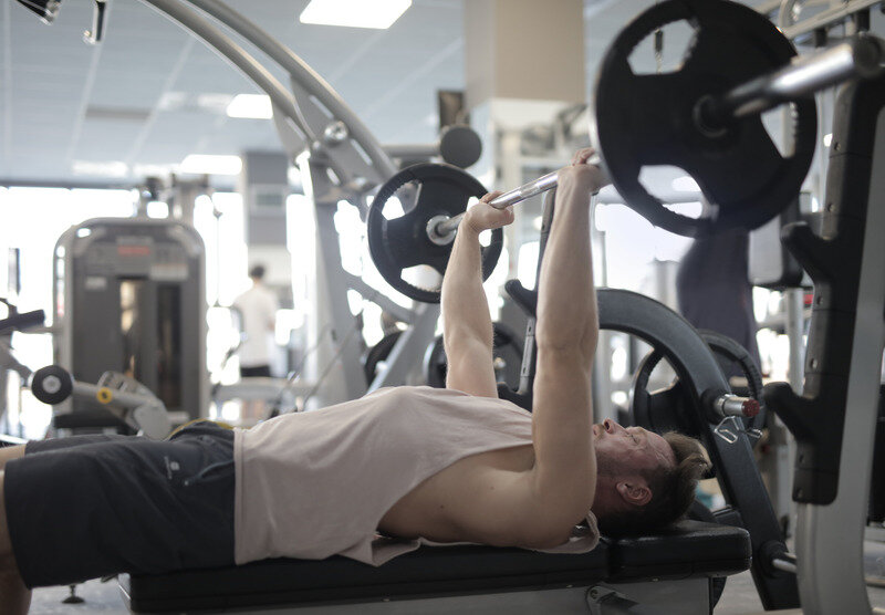 Canva - Muscular sportsman training with heavy barbell during weightlifting workout in modern gym.jpg