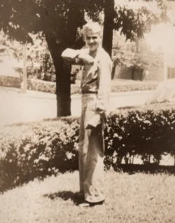 My father (at 18), Drew Wilson, showing off his private stripe, on leave from basic training, at home in Columbus Ohio in late summer of 1943.