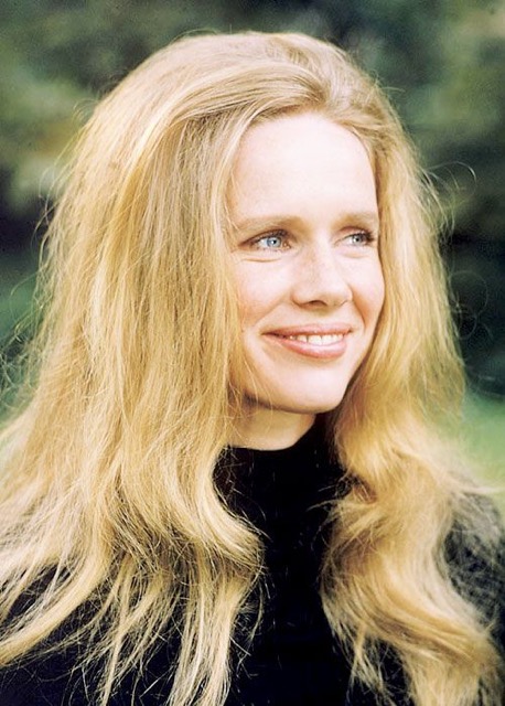 A serene, golden-haired woman with a soft and calm expression.