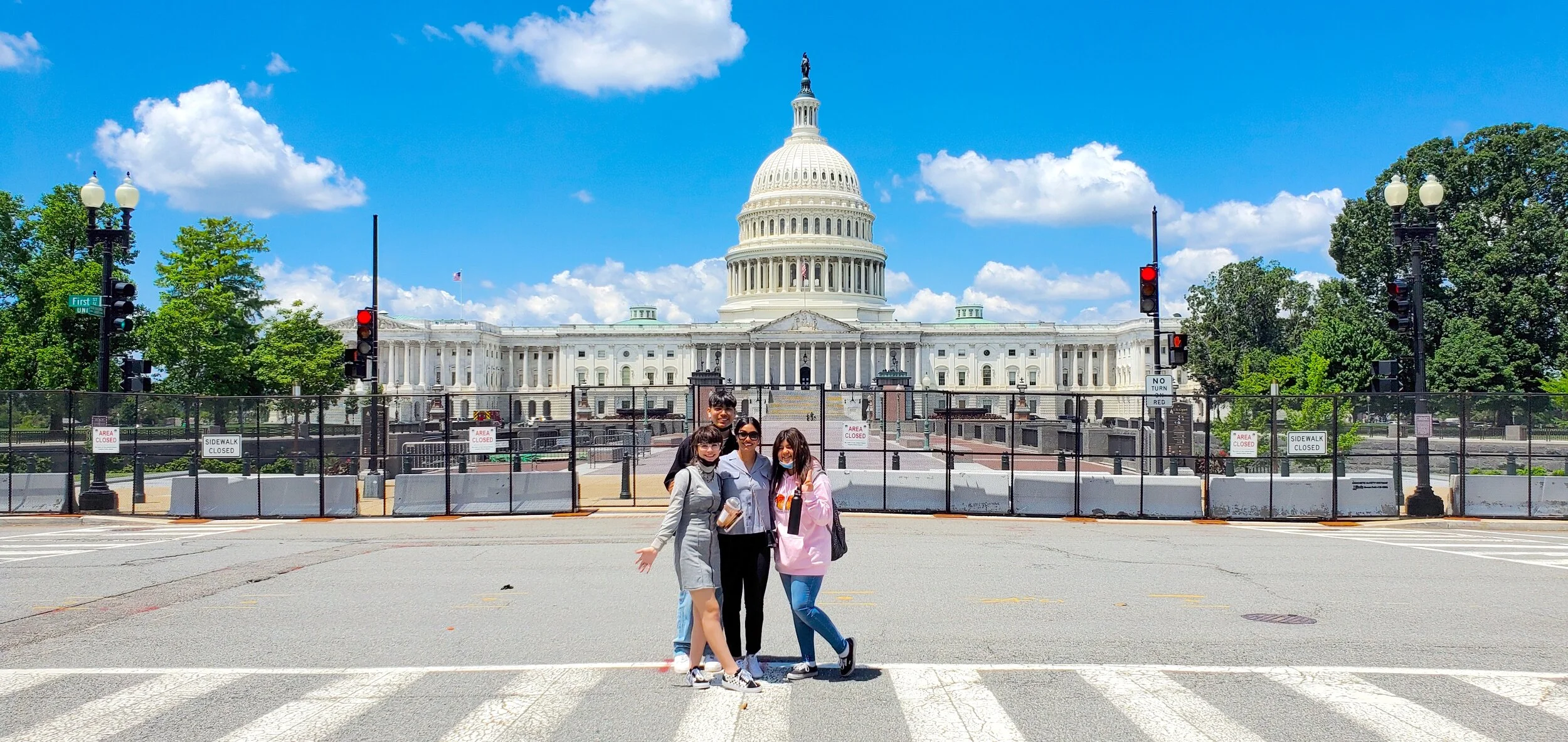 Three Club members and Unit Director Star Ramos smile for a photo in front of the Capitol Building.