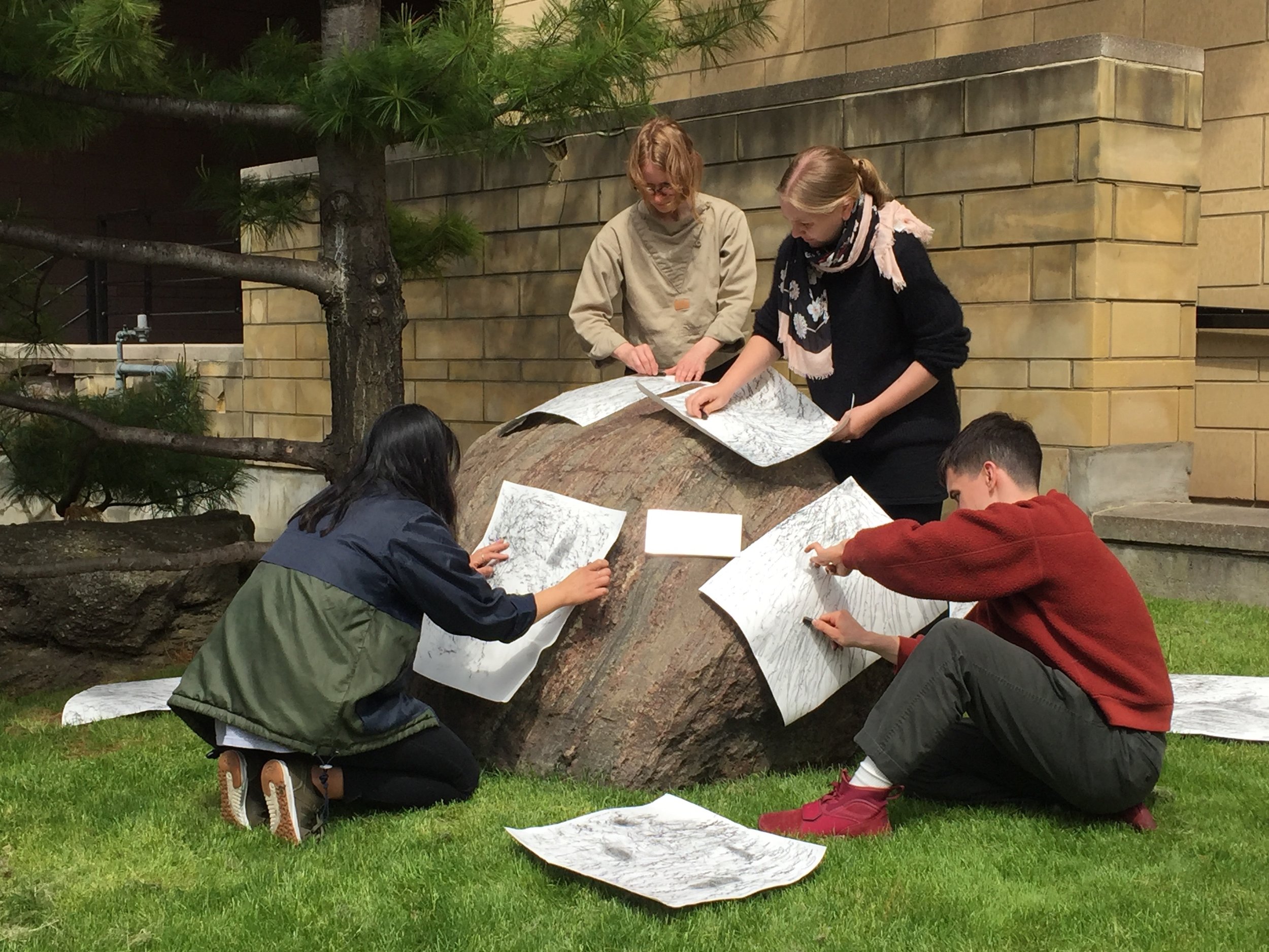 Workshop participants make rubbings of erratic glaciers as part of the boulder kite making (photo by Meghan Price)