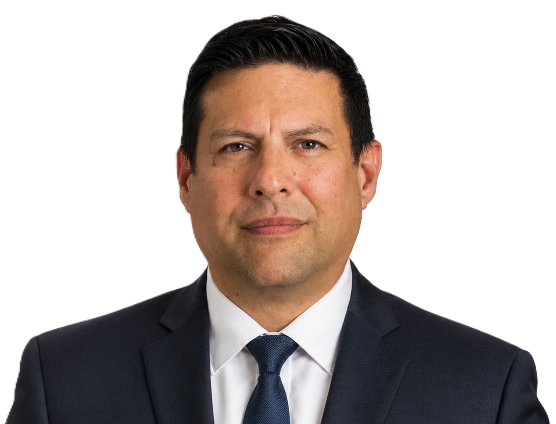A man wearing a gray suit, white shirt, and a blue striped tie, looking directly at the camera with a neutral expression.