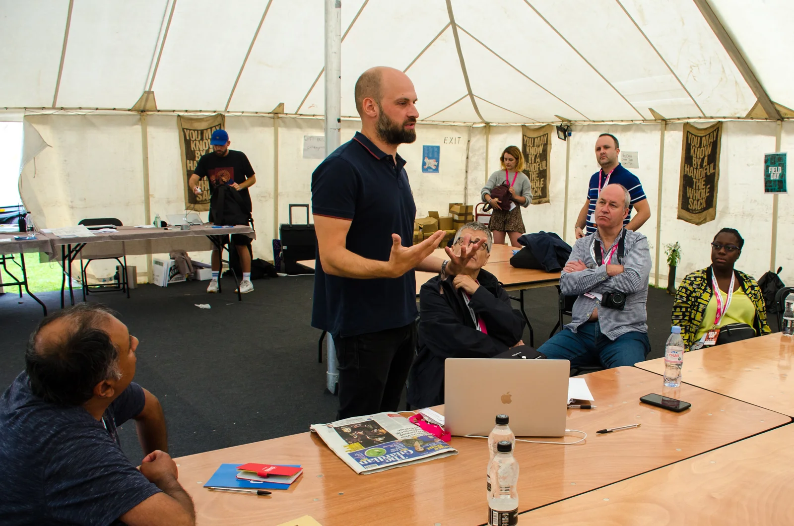 Photographer David Levene stands at a table presenting to other photographers