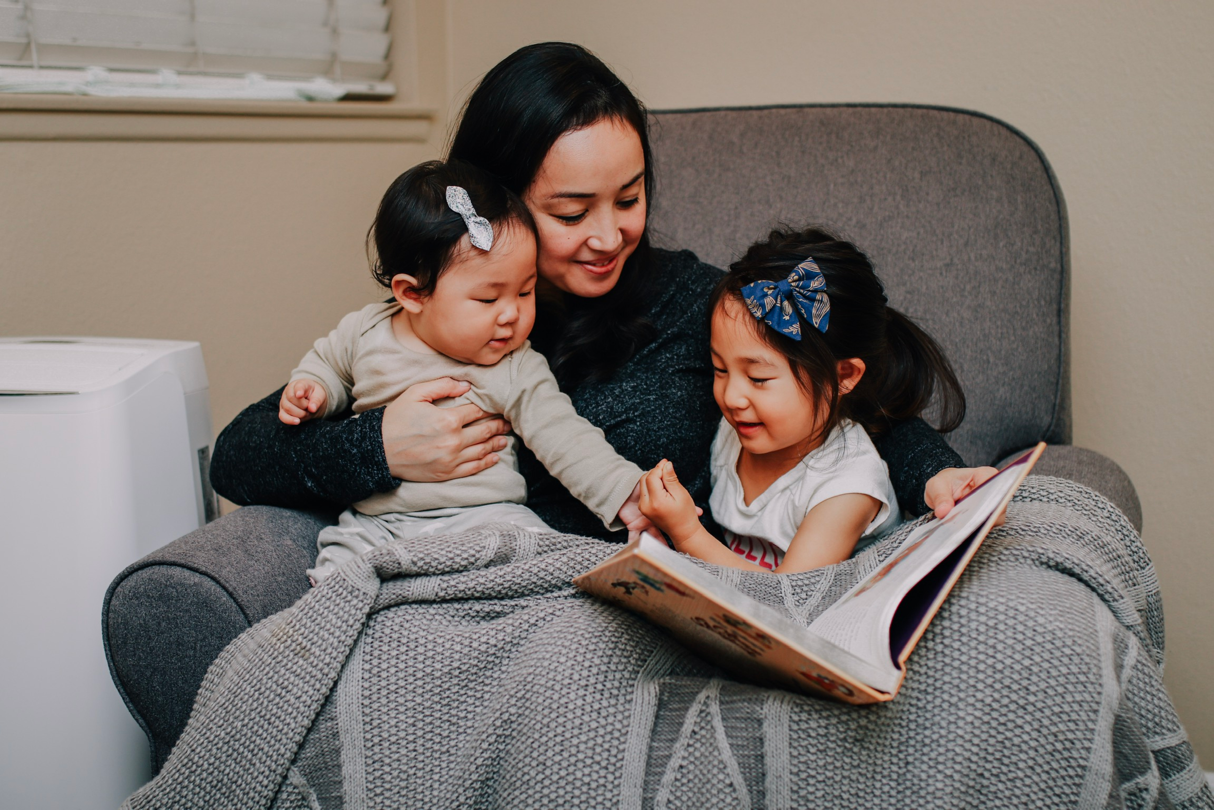 Mother reading book with kids