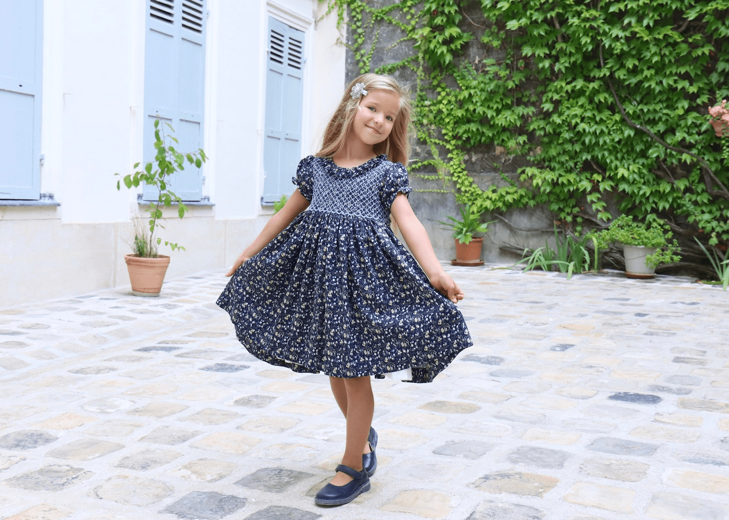 Young girl in a beautiful smocked French dress, special gift from Paris, L’Île aux Fées