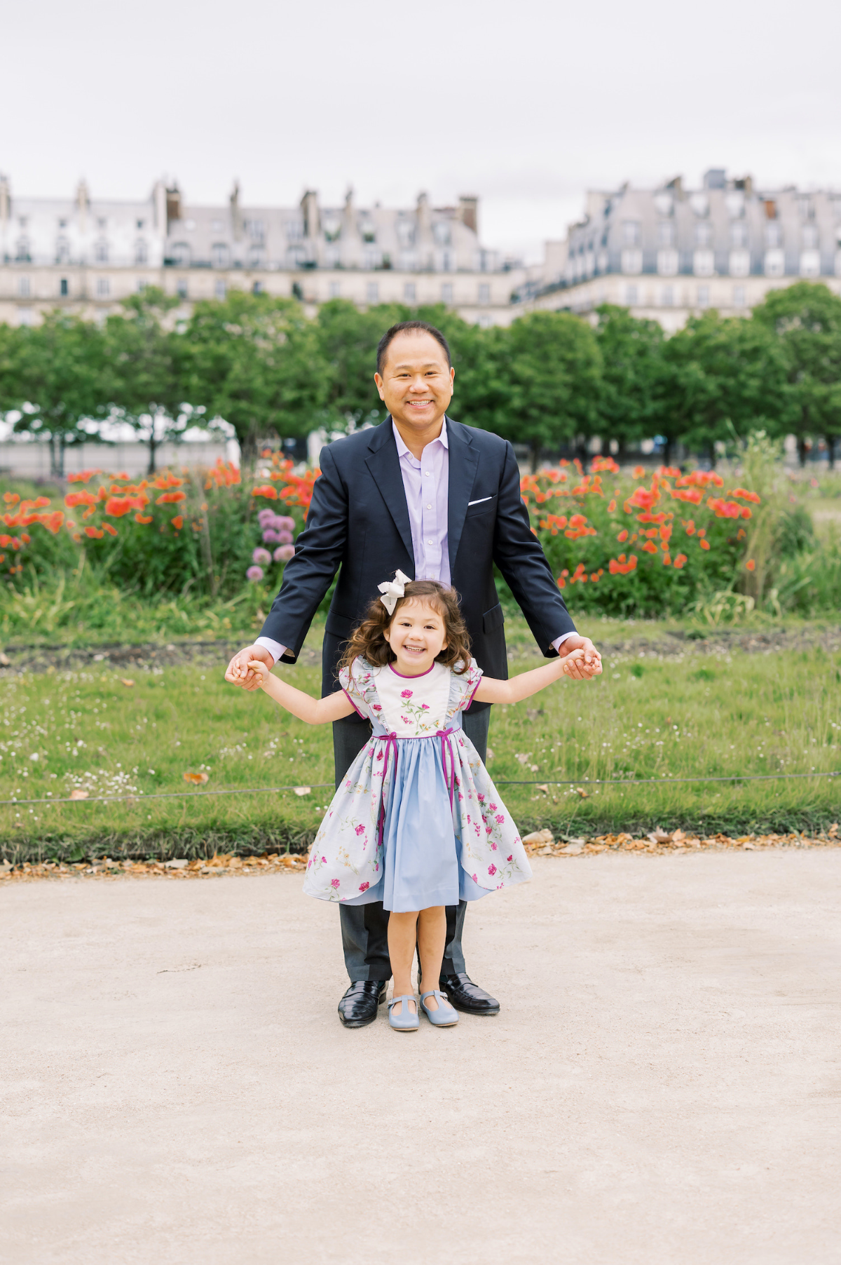 Father and daughter in a beautiful French children's dress in Paris Tuileries