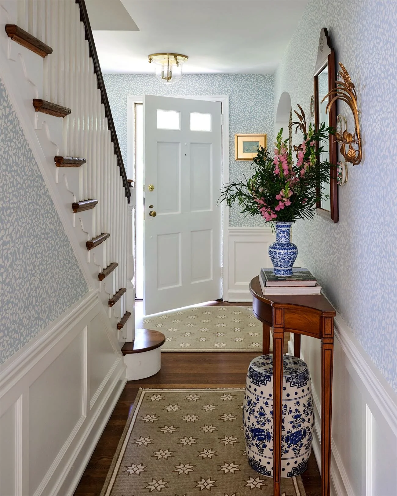 One of my favorite transformers in my home!  What was a tiny blank foyer has transformed into a welcoming pattern filled space. I added wainscoting, wallpapered (almost) every inch, and layered in soft carpets. The original archways in the home add s
