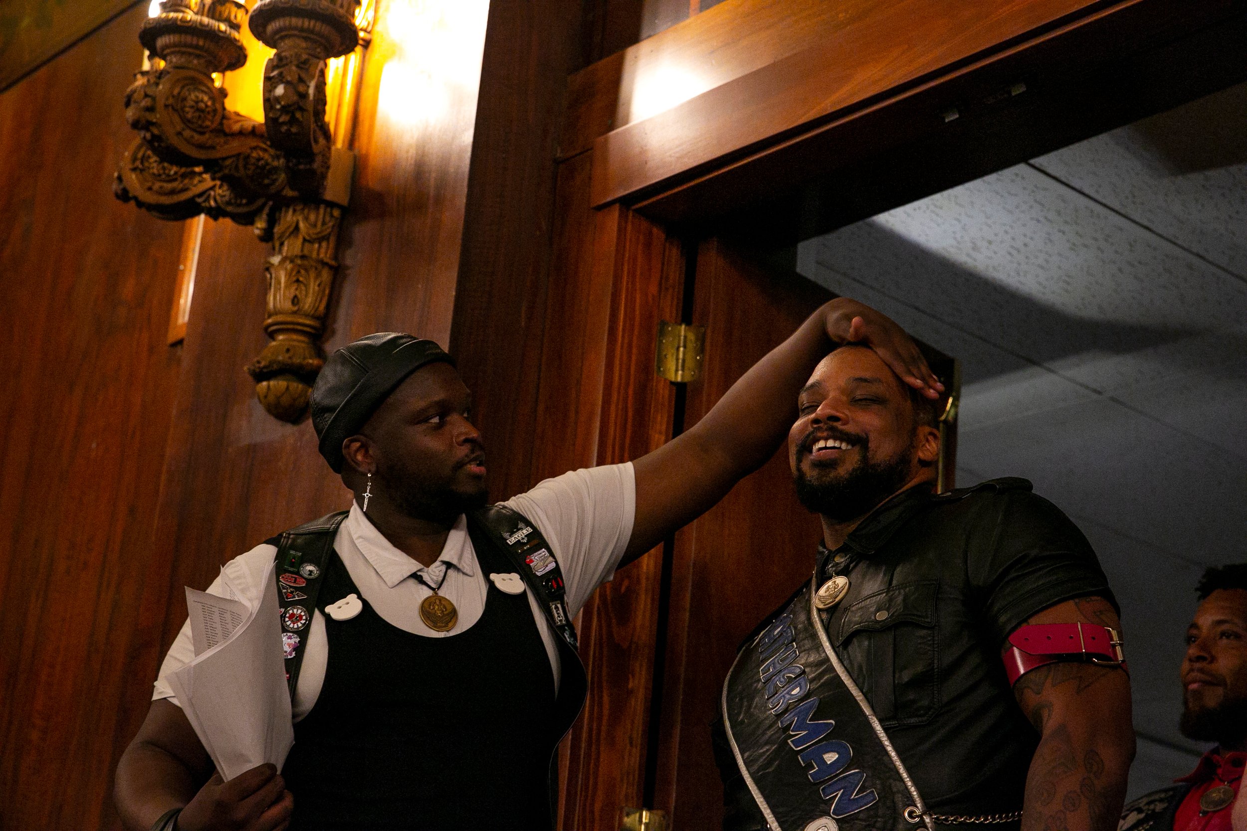  Contestant Handler Kenzo Onyx, wipes Leatherman of Color 2023, Phobos Onyx’s brow before he makes his debut entrance during the Opening Ceremonies of International Mister Leather 45, held in The Florentine Room at The Congress Plaza Hotel, Thursday 