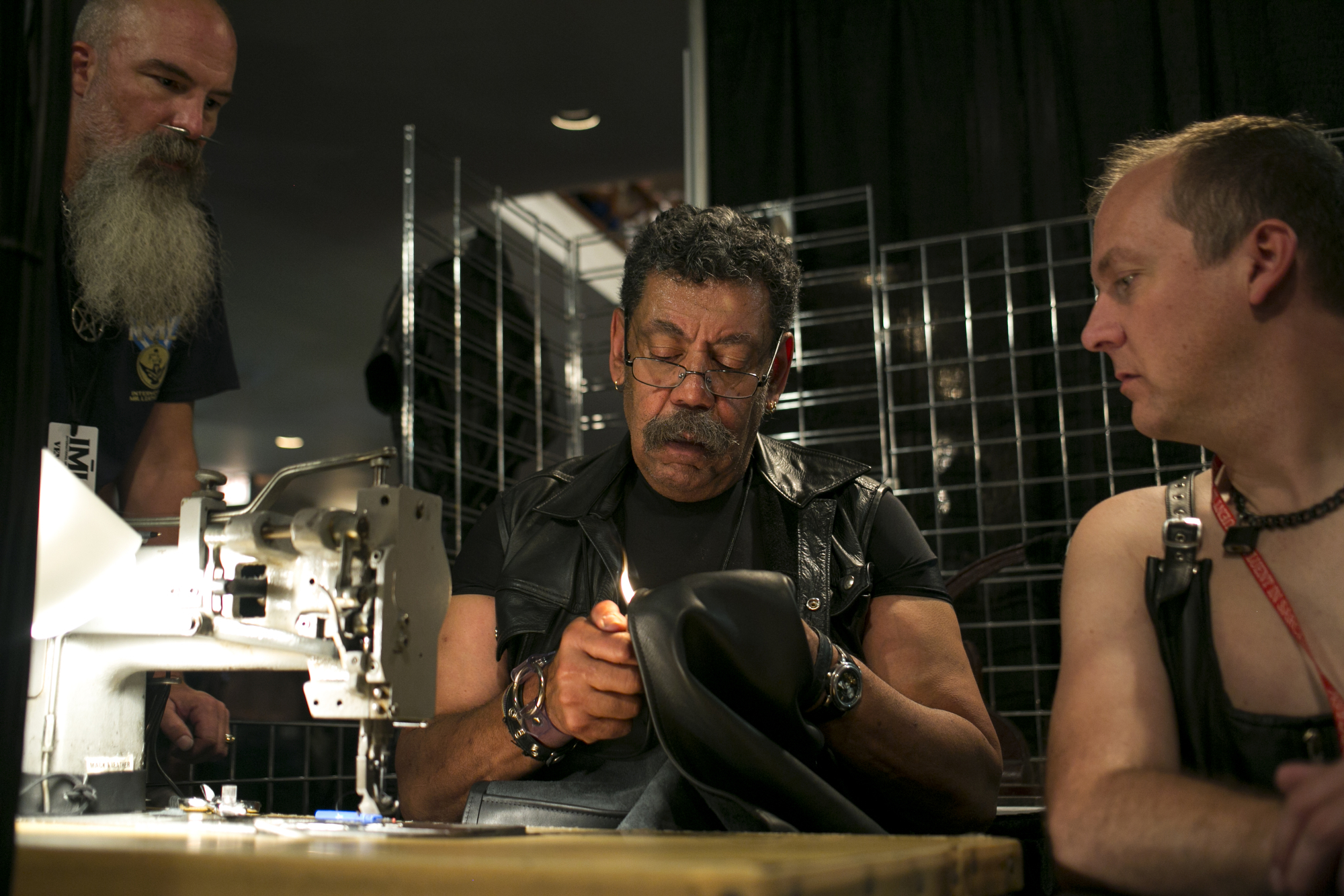  CJ, center, of CJ's Leather from Denver, repairs a vest duringThe 38th Annual International Mr. Leather held at The Congress Plaza Hotel in Chicago, on Sunday, May 29th, 2016. 