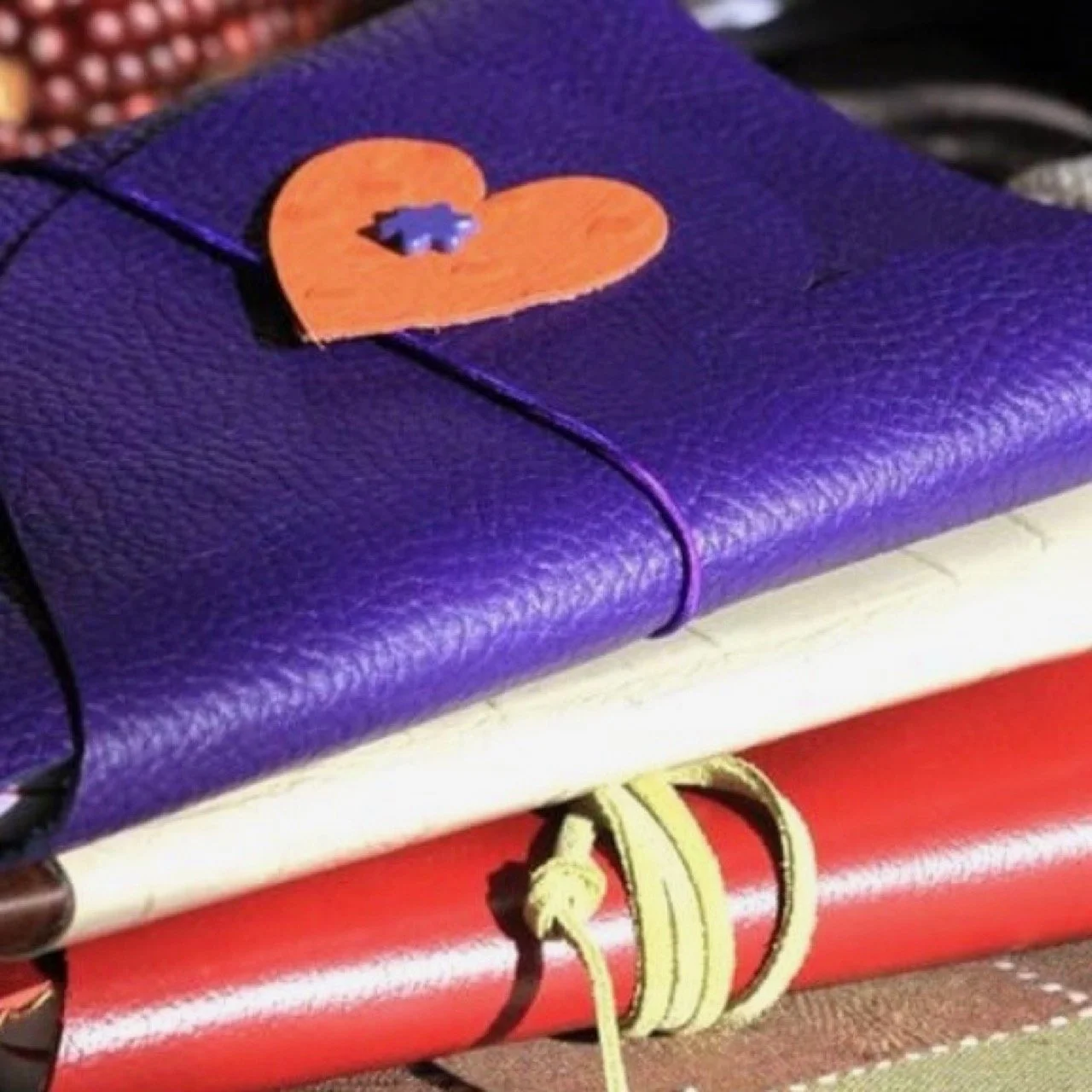 Close-up of three vinyl or leather covered journals