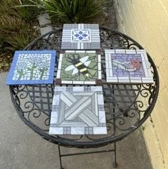 Five tile mosaics on garden table