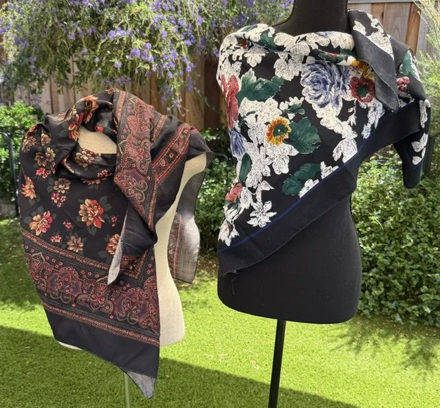 Two mannequins modeling large fabric scarves