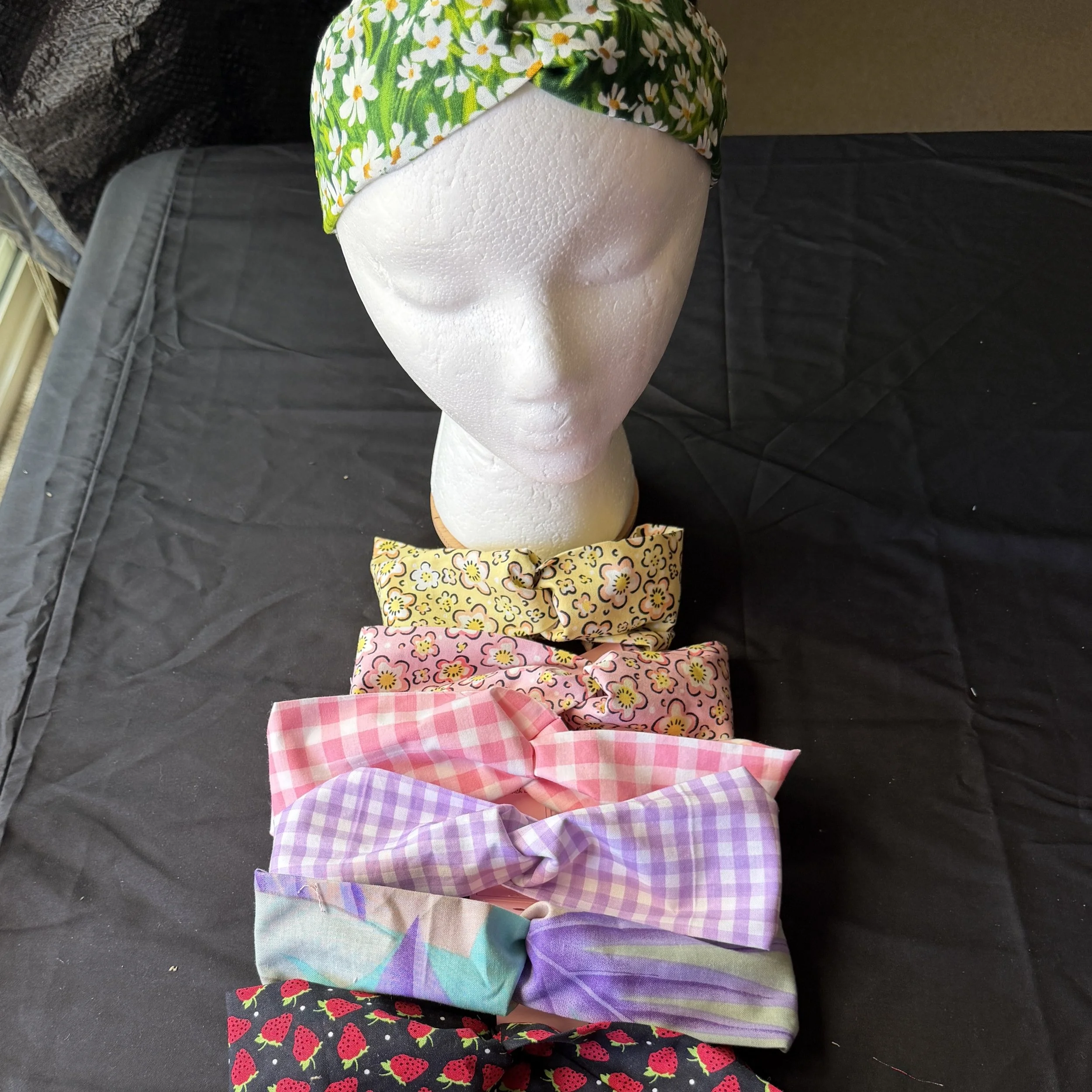 Six fabric headbands in front of bust modeling fabric headband