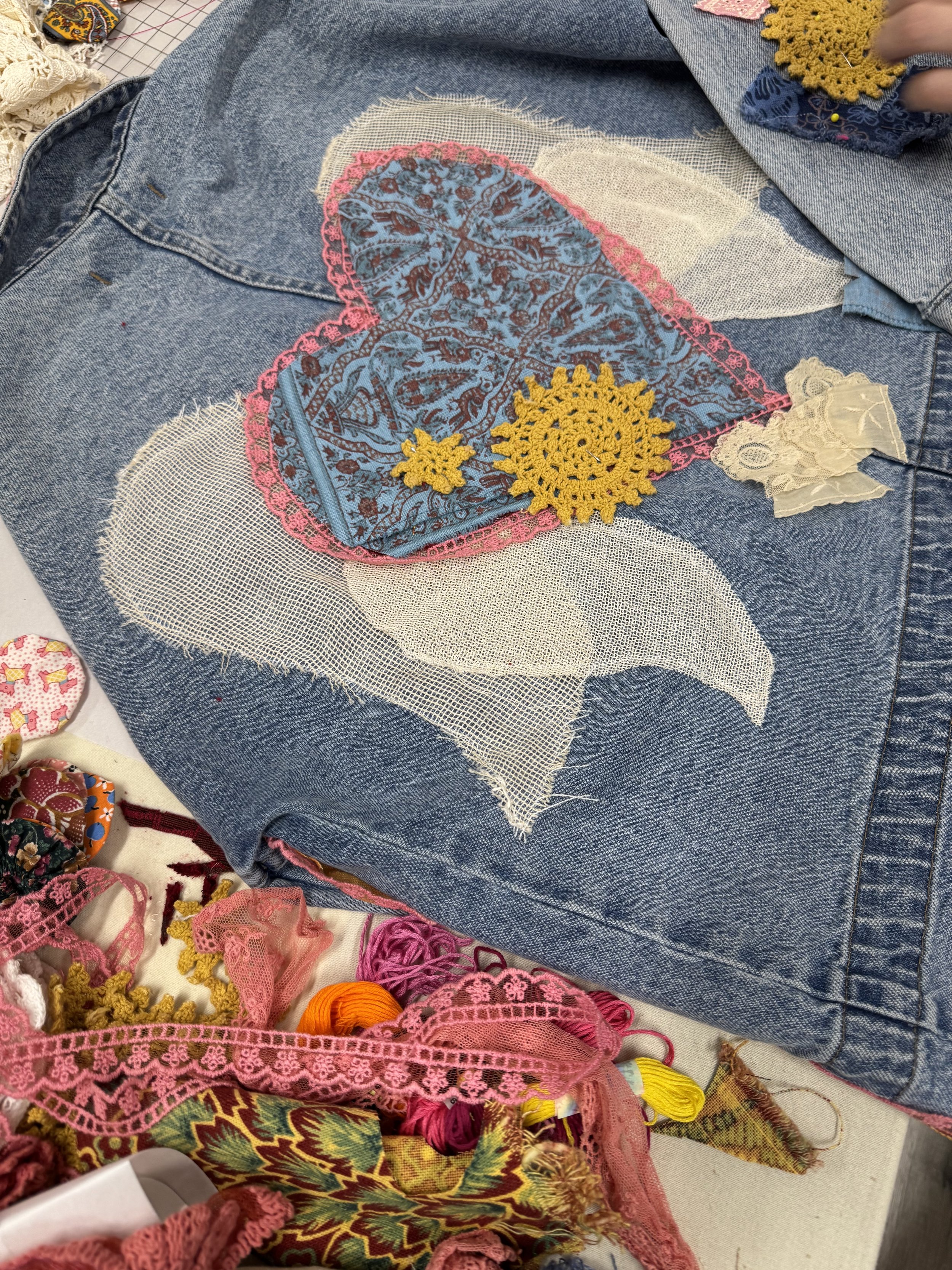 Winged heart appliqué on denim background