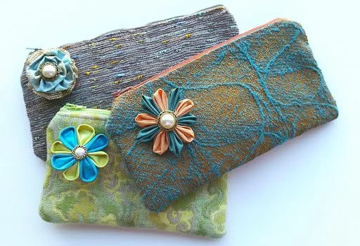 Three zipper pouches with fabric flower accents