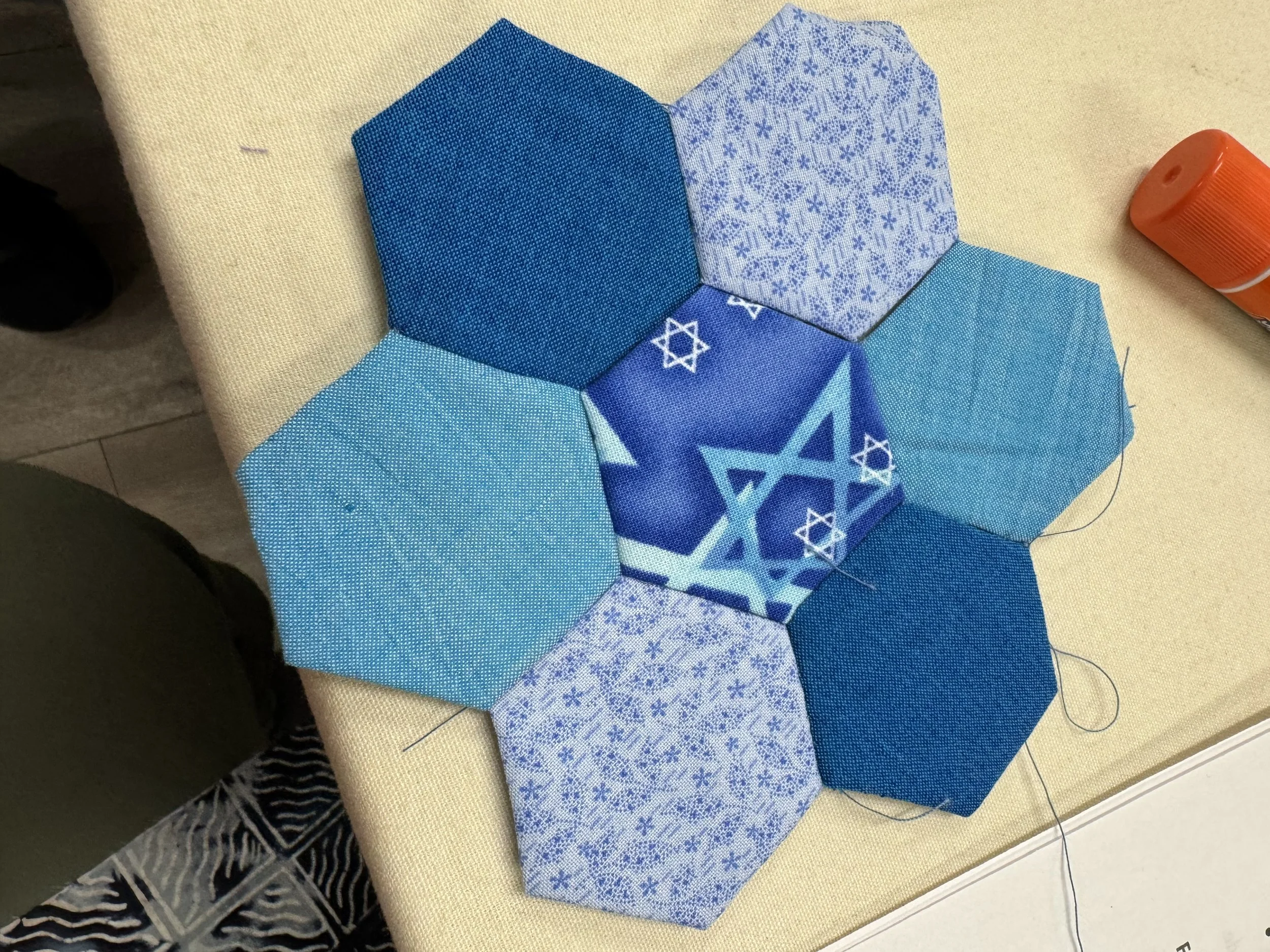 Hexagon-shaped pieces of blue fabric sewn to form flower shape