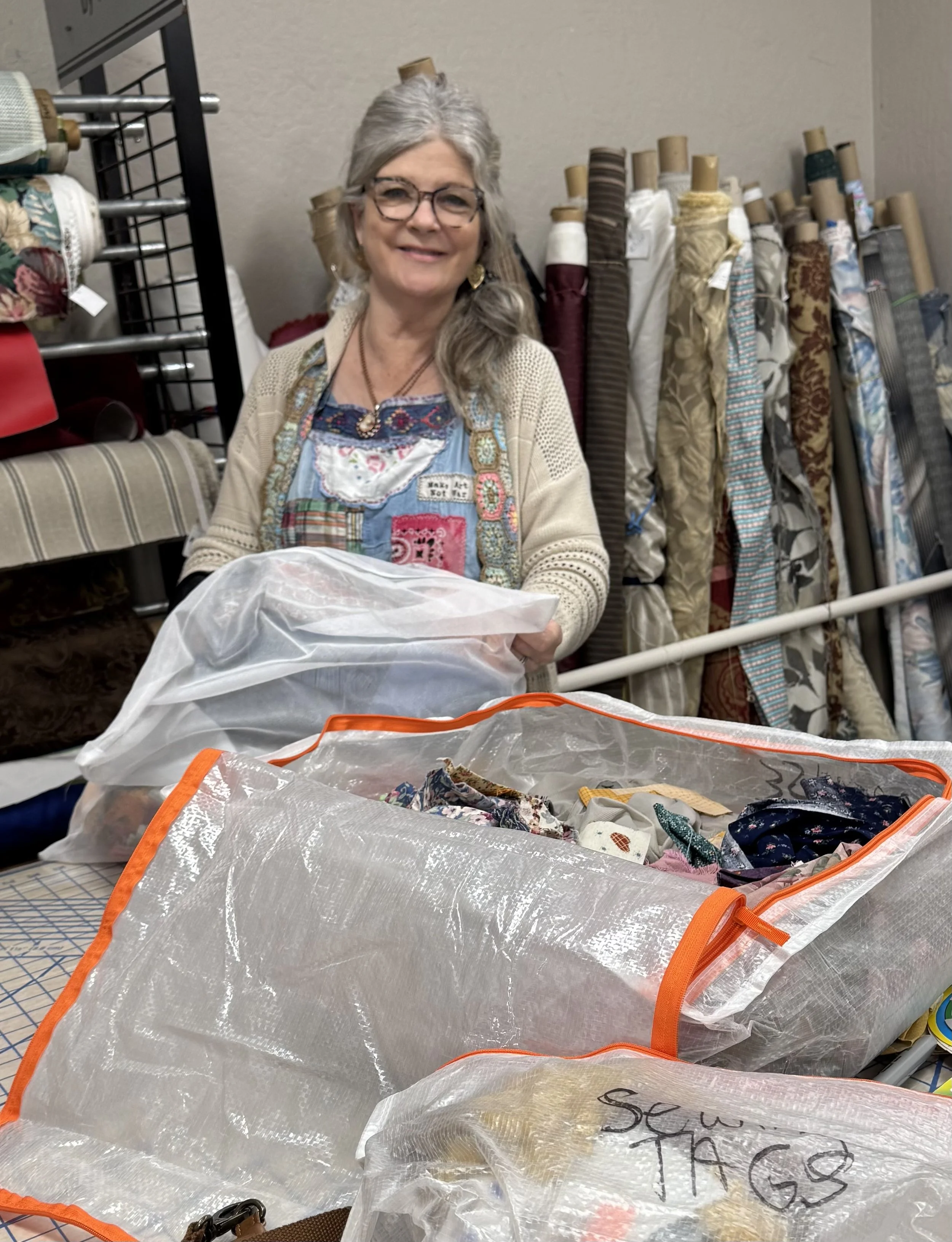 Woman standing behind table with fabric scraps