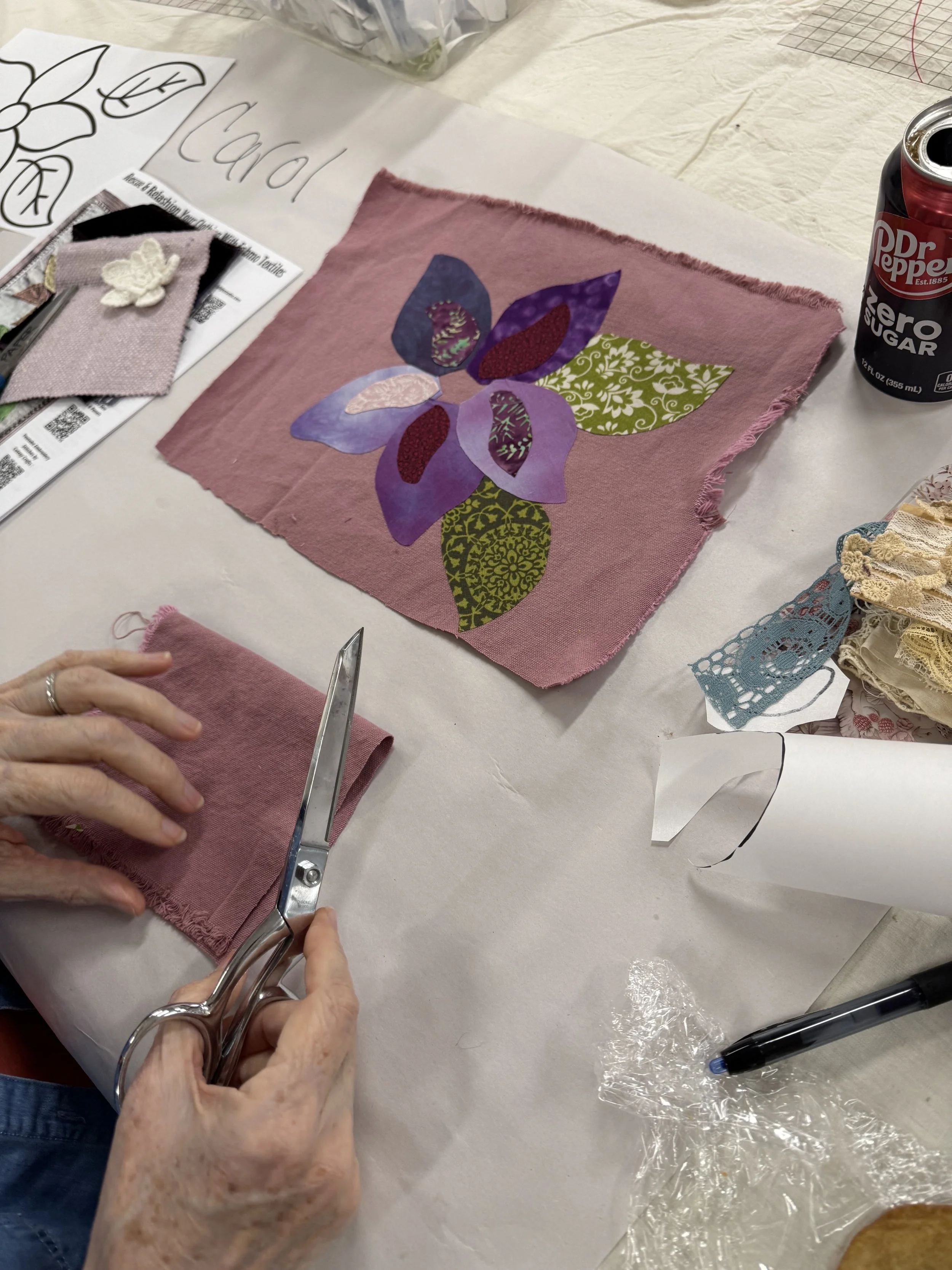 Close-up of purple flower appliqué on mauve fabric