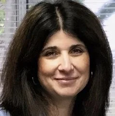 Photo of dark haired woman wearing blue shirt