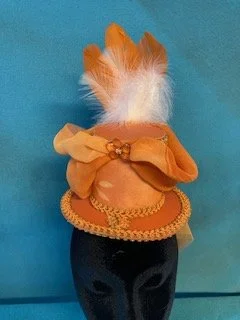 Handmade orange hat with feathers and bow