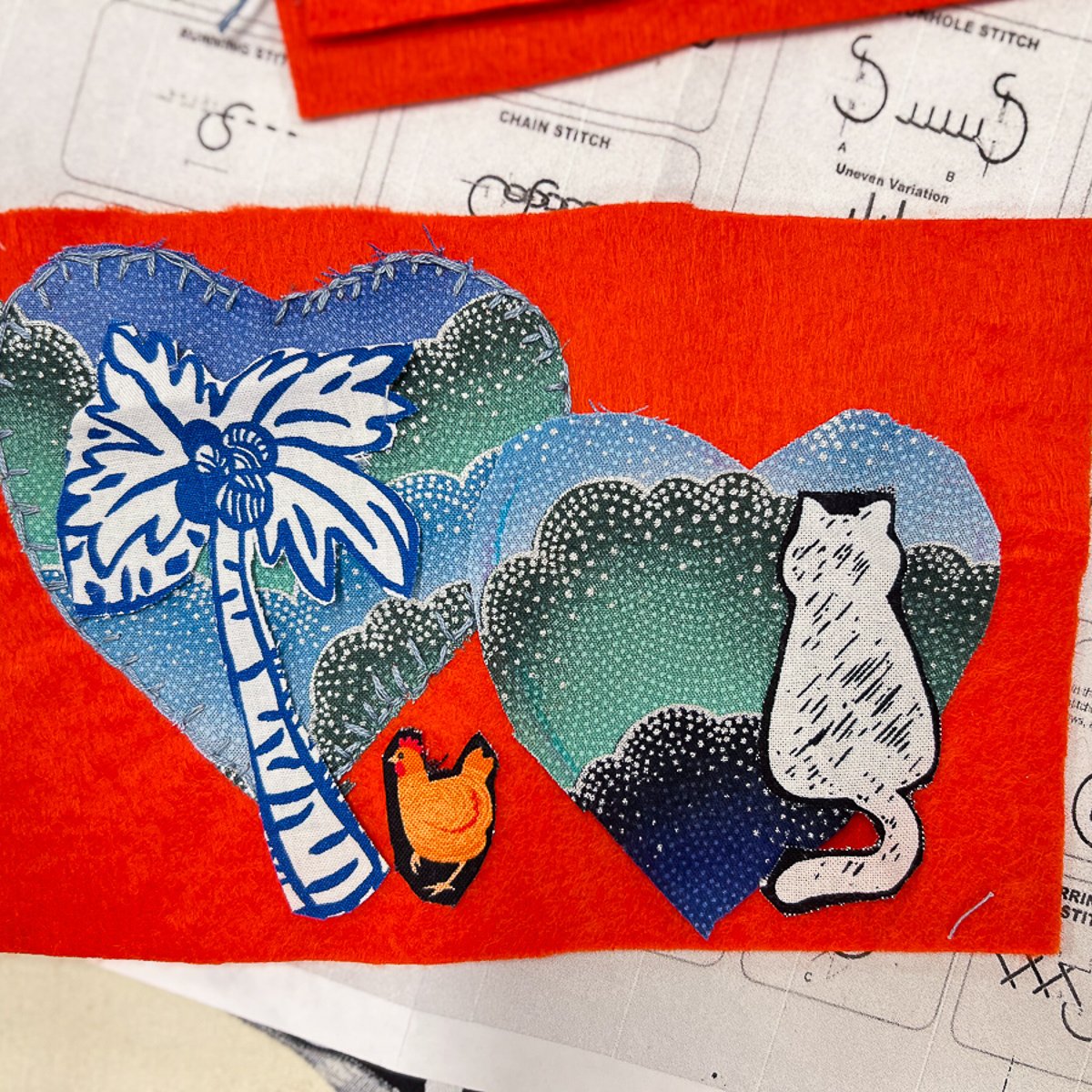 Double fabric heart design with cat and palm tree silhouette on red background