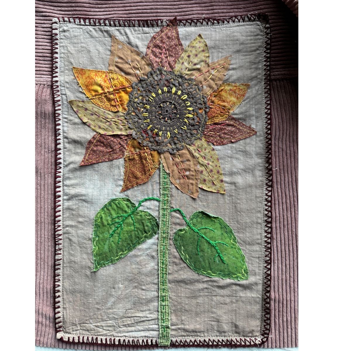 Fabric sunflower appliqué on white background