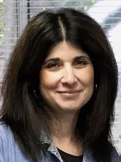 Photo of dark haired woman wearing blue shirt