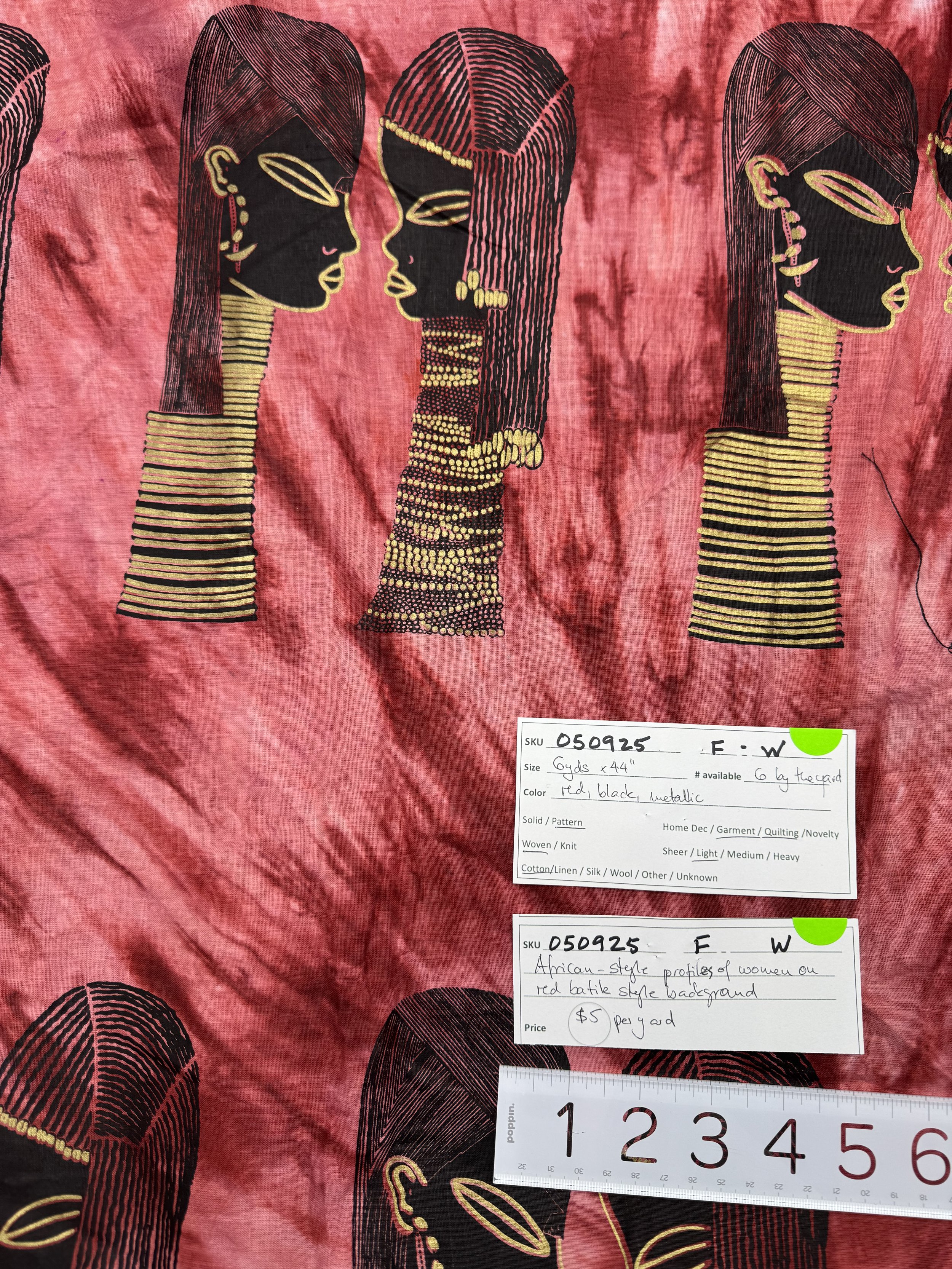 050925-F-W Profiles in black & gold on red batik, Cotton, 44" wide; by the yard