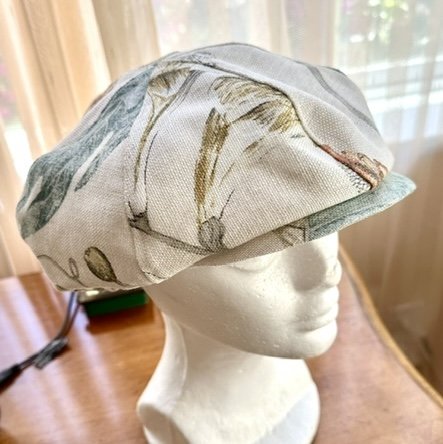 Bust wearing beige fabric pageboy hat