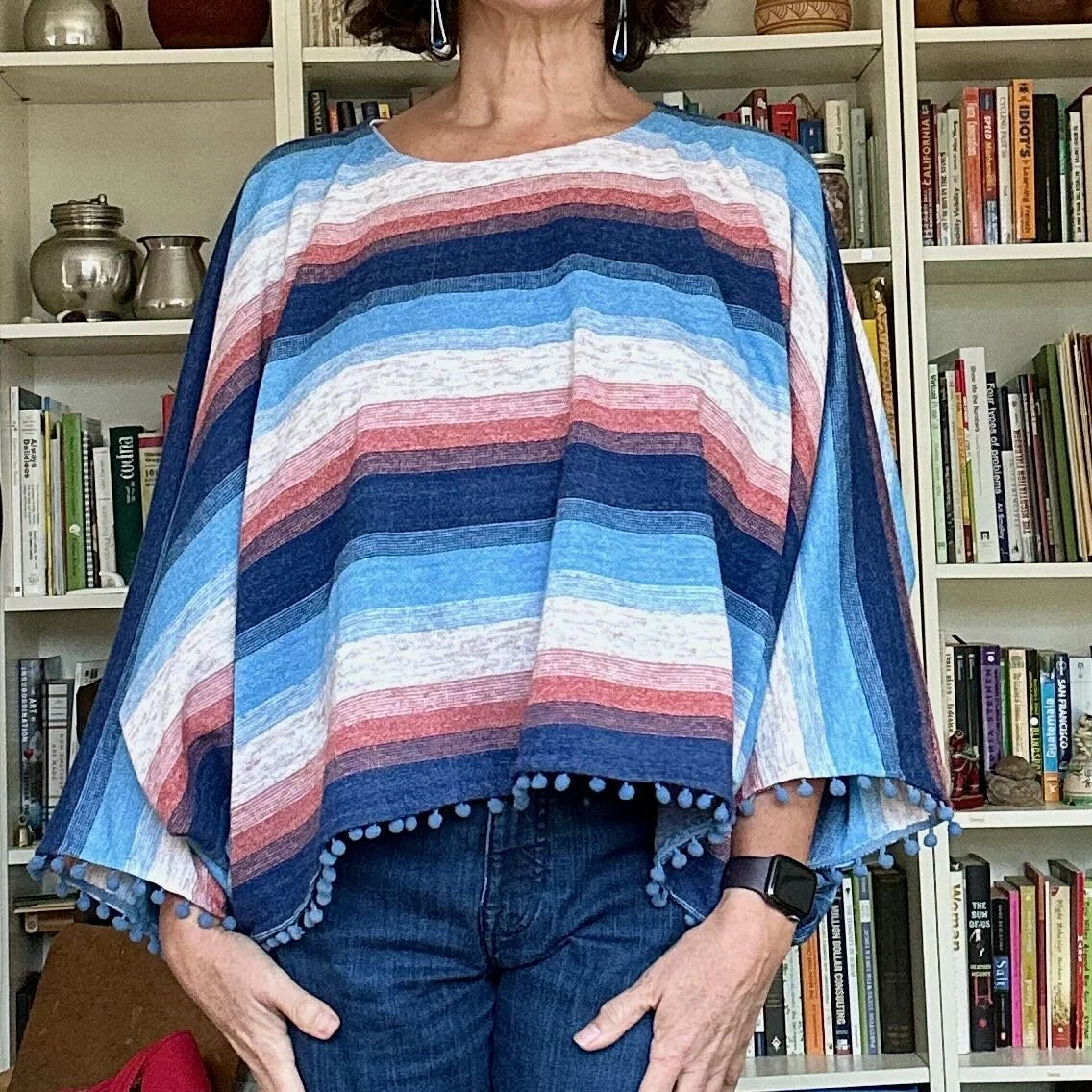Woman wearing blue, white and pink striped poncho