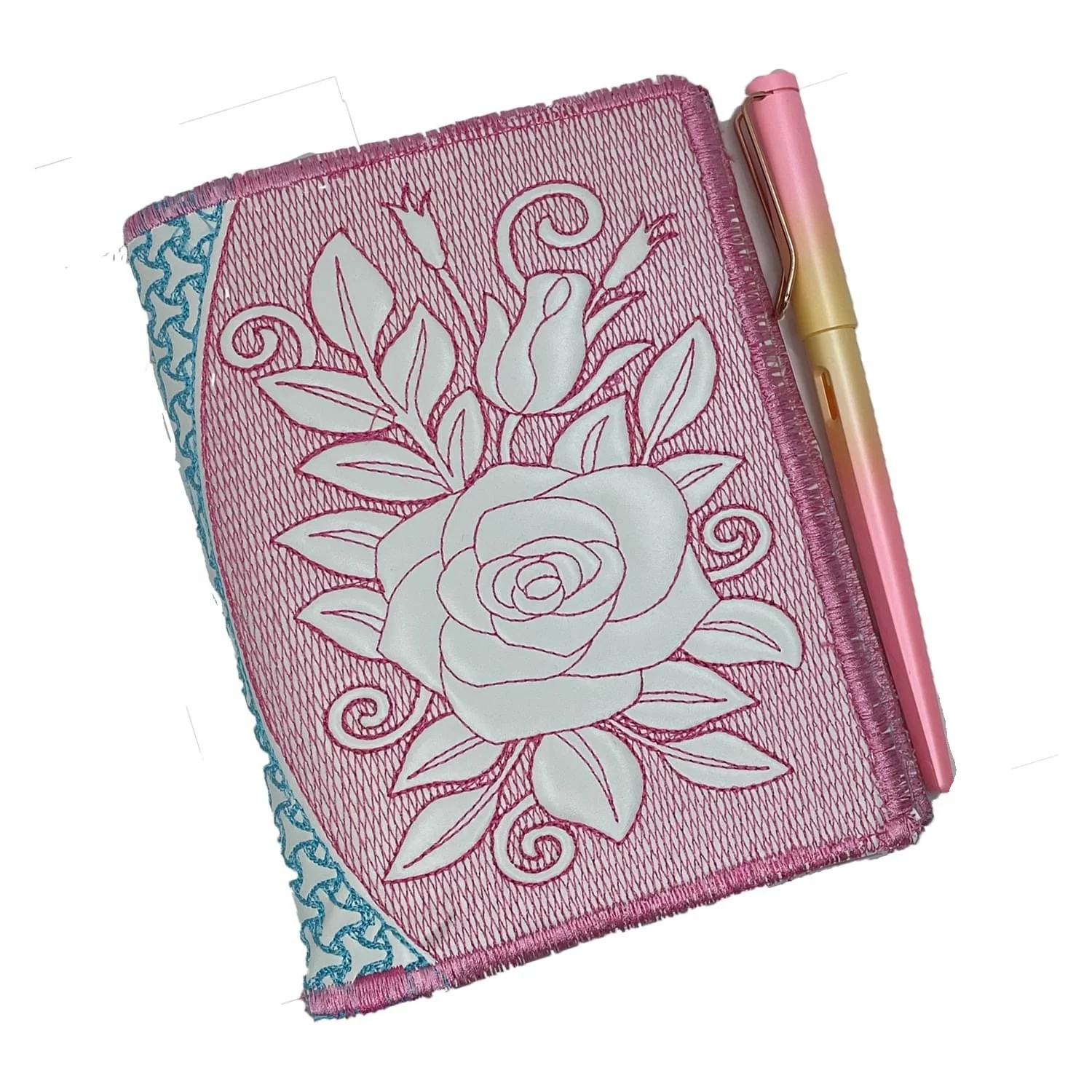 Pink fabric notebook with an off-white rose design on the cover.