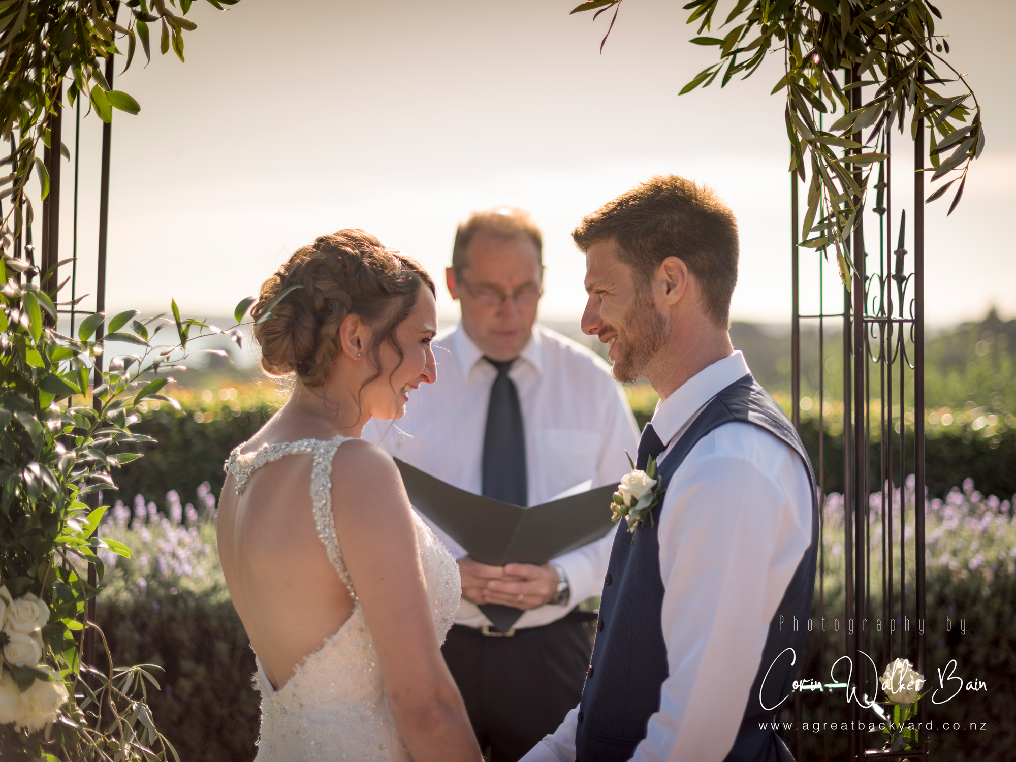 Ceremony smiles at Andy and Emma's Waiheke Island wedding by New Zealand wedding photographer Corin Walker Bain of a great backyard