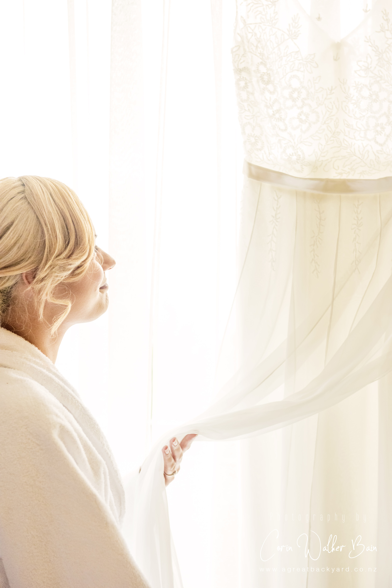 Bride looking at her dress, Jah and Teri's Queenstown wedding by New Zealand wedding photographer Corin Walker Bain of a great backyard