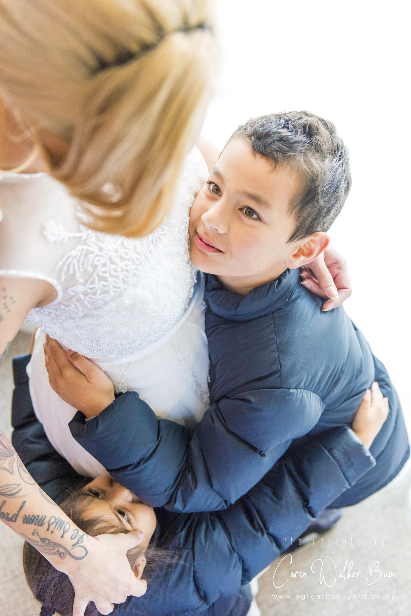 Family hugs at Jah and Teri's Queenstown wedding by New Zealand wedding photographer Corin Walker Bain of a great backyard