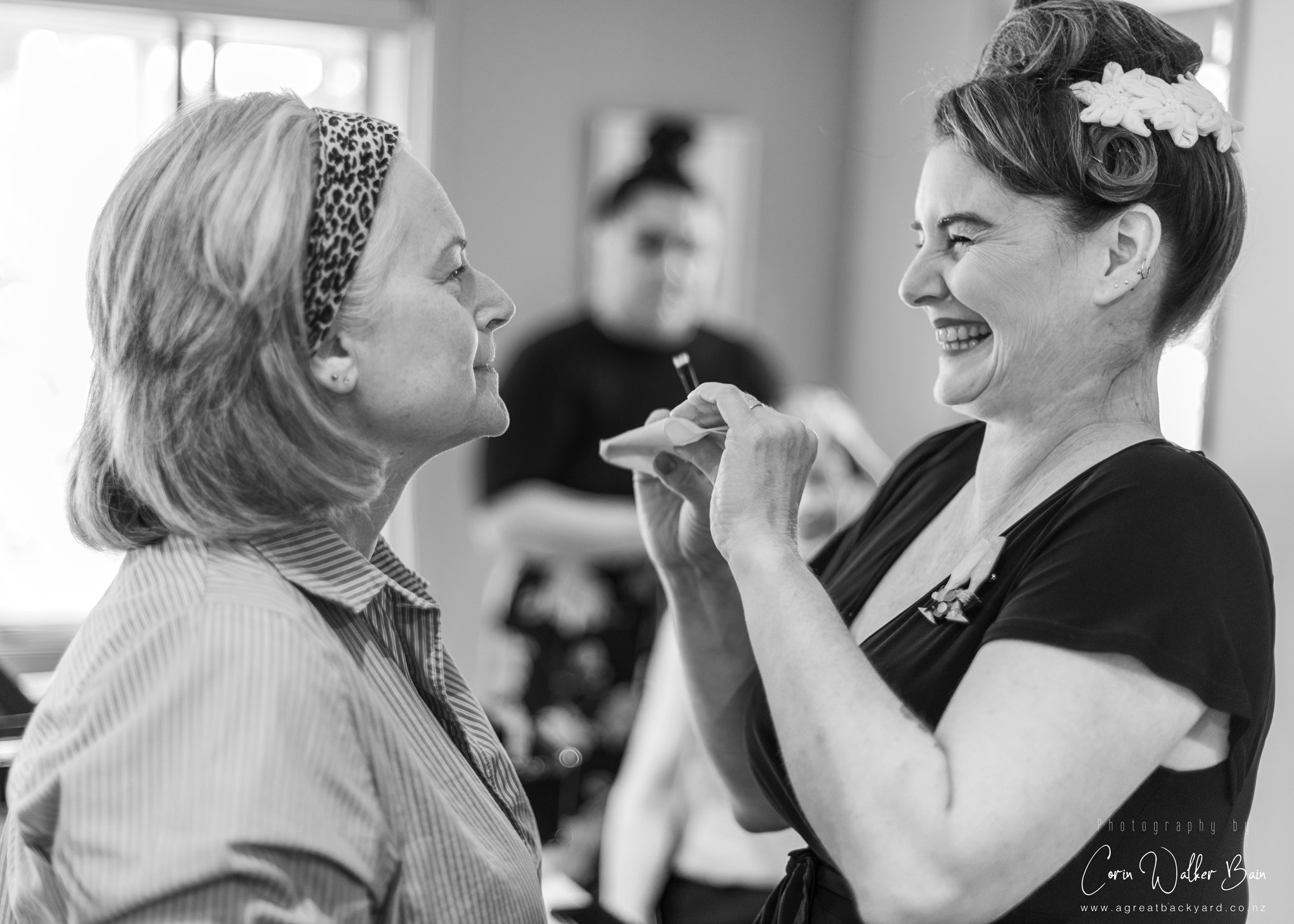 Bridesmaid and makeup artist giggling