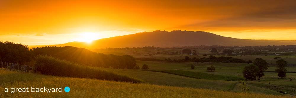 A vivid orange sunset over Pirongia Mountain by Corin Walker Bain | a great backyard