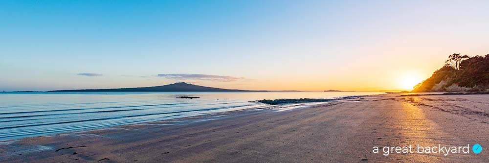 View down Narrowneck Beach towards Mt Rangitoto Island at dawn, Auckland
